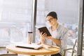 Handsome businessman in casual wear and eyeglasses is using a laptop in cafe Royalty Free Stock Photo