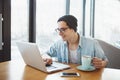 Handsome businessman in casual wear and eyeglasses is using a laptop in cafe Royalty Free Stock Photo