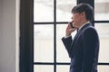 Handsome businessman checking emails on the phone near the window in the loft interior studio Royalty Free Stock Photo