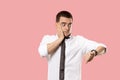 Handsome businessman checking his wrist-watch Isolated on pink background Royalty Free Stock Photo