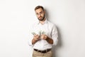 Handsome businessman counting money and looking at camera, standing serious against white background Royalty Free Stock Photo