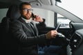 Handsome businessman driving car to airport, going on business side view, copy space. Happy man in stylish suit going to Royalty Free Stock Photo