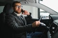 Handsome businessman driving car to airport, going on business side view, copy space. Happy man in stylish suit going to Royalty Free Stock Photo