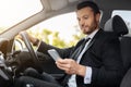 Handsome businessman driving car, using mobile phone Royalty Free Stock Photo