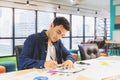 Handsome businessman in eyeglasses is making notes and smiling while working with a laptop at home Royalty Free Stock Photo