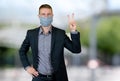 Handsome businessman with face mask outdoor in city