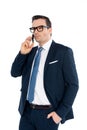 handsome businessman in formal wear talking by smartphone and looking away Royalty Free Stock Photo