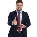 Handsome businessman gesturing ok and holding his phone Royalty Free Stock Photo