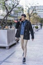 A handsome businessman having a conversation on his smartphone while walking in the street near his office Royalty Free Stock Photo