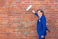 Businessman in his 50s standing at brick wall with paint roller