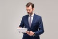 Handsome businessman holding clipboard and signing documents ,posing on grey studio background. Successful people. Insurance agent Royalty Free Stock Photo