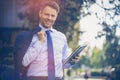 Handsome businessman holding dairy and blazer