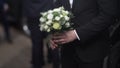 Handsome businessman holding flowers. Groom in a suit holding a bouquet of flowers. Wedding boutonniere. Elegant man Royalty Free Stock Photo