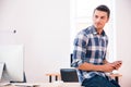 Handsome businessman holding smartphone and looking away Royalty Free Stock Photo