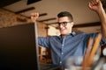 Handsome businessman with laptop having his arms with fists raised, celebrating success. Happy freelancer hipster in Royalty Free Stock Photo