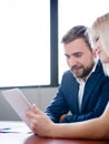 Handsome businessman and office woman working with tablet on a blurred background. Office meeting concept. Royalty Free Stock Photo