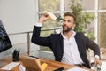 Handsome businessman playing with paper plane at desk in office Royalty Free Stock Photo