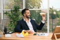 Handsome businessman playing with paper plane at desk in office Royalty Free Stock Photo