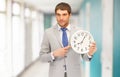 Handsome businessman pointing finger to wall clock Royalty Free Stock Photo