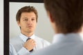 Handsome businessman preparing to official event, straighten tie Royalty Free Stock Photo