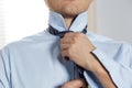 Handsome businessman preparing to official event, straighten tie Royalty Free Stock Photo