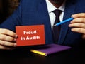 A handsome businessman showing a blank piece of paper with sign Fraud in Audits . Close-up shot. Soft focus