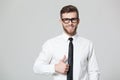 Handsome businessman showing thumbs up sign on gray background.
