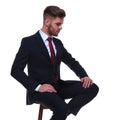 Handsome businessman sitting on chair looks down to side Royalty Free Stock Photo