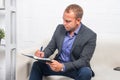 Handsome businessman sitting on couch with notebook at home in the living room