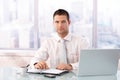 Handsome businessman sitting at desk in office