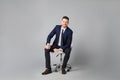 Handsome businessman sitting in office chair on grey background Royalty Free Stock Photo