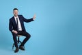 Handsome businessman sitting in office chair on light blue background Royalty Free Stock Photo