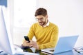 Handsome businessman sitting in the office and text messaging on Royalty Free Stock Photo