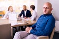 Handsome businessman sitting proudly in front of his business team