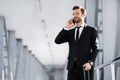 Handsome businessman standing in airport, talking on phone Royalty Free Stock Photo