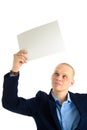 Handsome businessman in stylish suit holding empty sheet of paper over his head isolated on white background Royalty Free Stock Photo