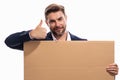 Handsome businessman in suit holding empty board on studio background. Business man with thumb up showing blank Royalty Free Stock Photo