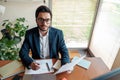 Handsome businessman in suit working with documents from home office and looking at camera Royalty Free Stock Photo