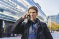 A handsome businessman talking on the cell phone near his office. Copy space Royalty Free Stock Photo