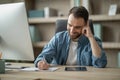 Handsome Businessman Talking On Cellphone And Taking Notes While Working In Office Royalty Free Stock Photo