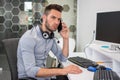 Handsome businessman talking on the phone and listening his client with attention at office desk. Royalty Free Stock Photo