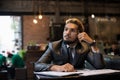 Handsome businessman thinking about work while working at cafe. Royalty Free Stock Photo