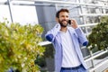 Handsome businessman using mobile phone in front of office build Royalty Free Stock Photo