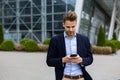 Handsome businessman using smartphone and smiling. Happy young man using mobile phone apps, texting message, browsing Royalty Free Stock Photo