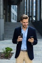 Handsome businessman using smartphone and smiling. Happy young man using mobile phone apps, texting message, browsing Royalty Free Stock Photo