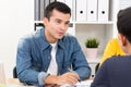 Handsome businessman wearing casual jean shirt discussing documents in the meeting Royalty Free Stock Photo