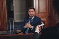 Handsome businessman wearing suit in Hotel check at reception or front office being given key card Royalty Free Stock Photo