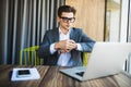 Handsome businessman working with laptop in office and looking at hand clock at time Royalty Free Stock Photo