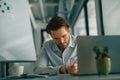 Focused male freelancer making notes during working on laptop sitiing desk in coworking Royalty Free Stock Photo