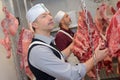 Handsome butcher in front carcasse Royalty Free Stock Photo